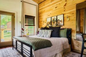 ein Schlafzimmer mit einem Bett in einem Zimmer mit Holzwänden in der Unterkunft Romantic Cabin - The Woodland Nook in Sevierville