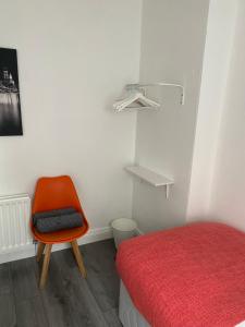 a room with a bed and a orange chair at Twin Room - Botanic, Belfast in Belfast