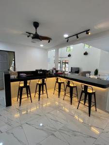a bar in a room with chairs and a table at 803 Villa AFamosa Villa in Kampong Ulu Pegoh