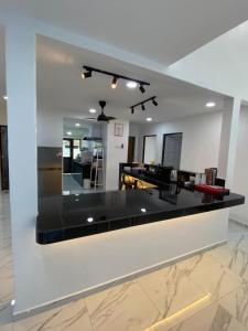 a white kitchen with a black counter top at 803 Villa AFamosa Villa in Kampong Ulu Pegoh