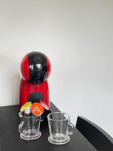 a red coffee maker with two glasses on a table at Splendide studio de Giverny Vernon Paris in Vernon
