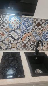 Una encimera de cocina con fregadero y azulejos en Pomona Guest House, en Salerno