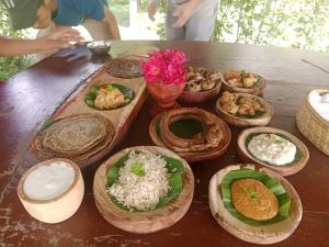 Una mesa de madera con platos de comida encima. en Olive Eco Village Hotel, en Pārtol