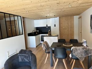 a kitchen and living room with a table and chairs at Les loups blancs in Courchevel
