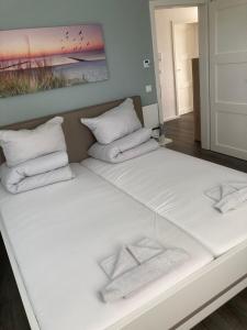 a bed with white pillows and a painting on the wall at Hafenapartment 621 in Zielow +6 photos
