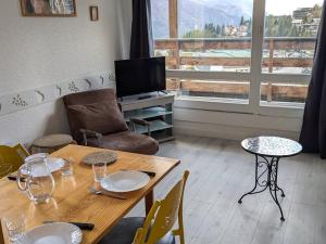 un salon avec une table et une télévision dans l'établissement Maxi Studio 5 pers. avec balcon, WIFI, pieds des pistes, calme, proche commerces et sports - FR-1-262-75, à Forest des Baniols