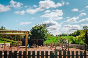 a playground with a swing set in a park at Sage Caravan 2 at Thurston Manor Leisure Park in Dunbar