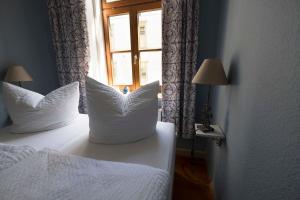 1 dormitorio con 2 camas con almohadas blancas y ventana en Fewo Leonhardt, en Görlitz