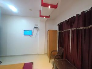 a room with a red curtain and a room with a table at Hemprabha Bed & Breakfast, Ratnagiri in Ratnagiri