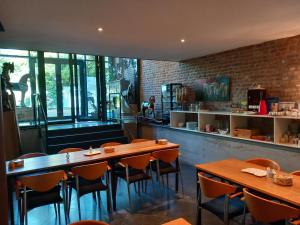 a restaurant with wooden tables and chairs and a brick wall at Meschermolen in Mesch