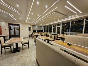 德奥加尔HOTEL MAA LAXMI PALACE的有桌椅和窗户的餐厅