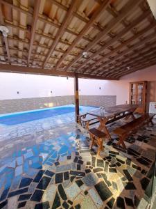 a swimming pool with a table and a mosaic floor at Casa aconchegante-lazer completo in Três Pontas