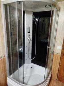 a shower with a glass door in a bathroom at Casa cu amintiri in Bacău