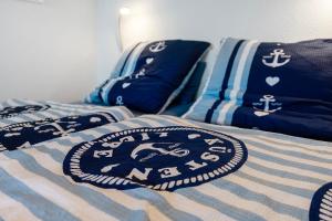 a bed with blue and white blankets and pillows on it at Fördetraum,erste Reihe,Strand 20 m in Laboe
