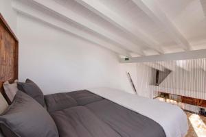 una camera da letto con un letto grande in una stanza bianca di Estúdio Casa Do Limoeiro a Nora