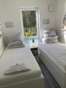 two twin beds in a room with a window at Hafenapartment 621 in Zielow