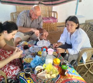 a group of people sitting around a table eating food at Roma House in Aswan +37 photos