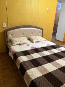 a bed with two pillows on it in a room at Economy - class apartment in Pavlodar