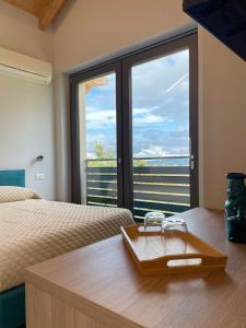 a hotel room with two beds and a large window at Cascina Ricardin in Coazzolo