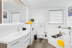 a white bathroom with a sink and a toilet at Svyvo Siegburg - Cozy Serviced Apartments near Cologne & Bonn in Siegburg