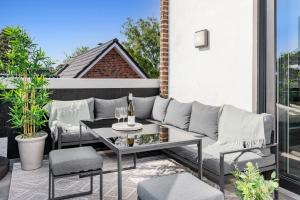 a patio with a couch and a table on a balcony at Svyvo Siegburg - Cozy Serviced Apartments near Cologne & Bonn in Siegburg +17 photos