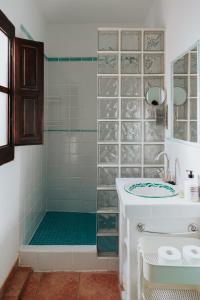 a bathroom with a shower with a tub and a sink at Casa del Patio in Pinos del Valle
