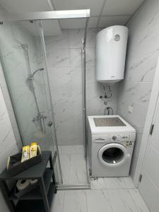 a shower stall with a washing machine in a bathroom at M&M Cozy Apartment-Free Parking in Skopje +35 photos