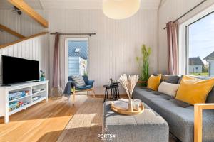 a living room with a couch and a tv at Ferienhaus Olpi Olpenitz in Olpenitz