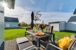 a patio with a table and chairs in a yard at Ferienhaus Olpi Olpenitz in Olpenitz