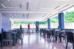 a dining room with tables and chairs and people standing at Hillview Hotel and Resort, Ajebamidele, Ado-Ekiti, Nigeria in Ado Ekiti