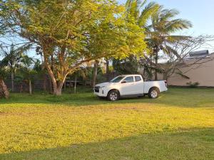 a white car parked in a yard next to a tree at CapNature in Saint-André