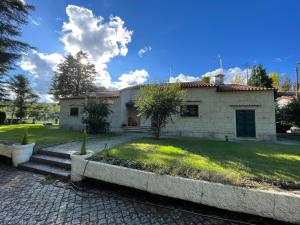 una pequeña casa blanca con un patio de césped en Retiro do Prior en Chaves