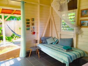 a bed sitting in a room with a window at Bungalow Kokonut Marie galante in Saint-Louis