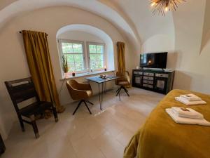 a room with two beds and a table and a window at Gewölbe-Stübchen im Herrenhaus in Schwarzenberg/Erzgebirge