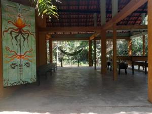einem Pavillon mit Bänken und einem Wandgemälde in der Unterkunft Caminho das pedras-Medicina, Consciência e espiritualidade- Hospedaria na floresta com saída ao Igarapé in Alter do Chao