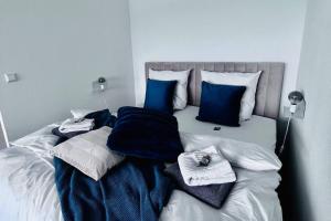 - un lit avec des oreillers et des serviettes bleus et blancs dans l'établissement Apartment mit Wintergarten & Grüner Aussicht im Schwarzwald, à Löffingen