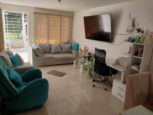 a living room with a couch and a tv on the wall at Espectacular Casa en Barbosa Santander in Barbosa