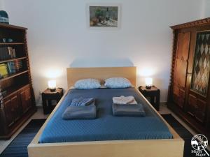 a bedroom with a large blue bed with two pillows at Minor Major Vendégház in Somogyacsa +37 photos