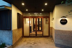 un ingresso di un edificio con una porta a vetri di 宿屋GONDO aioi a Nagano