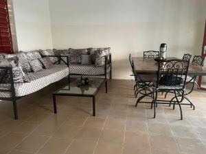 a living room with a couch and a table and chairs at Maison de campagne à Sipo in Sipo