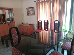 a glass table and chairs in a living room at Casa Esquina in Guaymallen