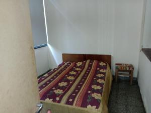 a small bedroom with a bed with a blanket on it at Casa Esquina in Guaymallen