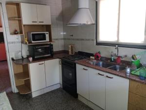 a small kitchen with a sink and a microwave at Casa Esquina in Guaymallen