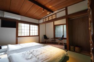 una camera da letto con un letto in una stanza con finestre di 宿屋GONDO aioi a Nagano