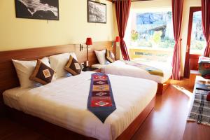 a hotel room with two beds and a window at Sapa Dragon Hotel in Sa Pa