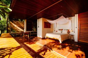 a bedroom with a bed on a wooden deck at A Casinha da Floresta in Gamboa