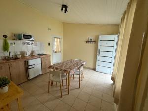 eine Küche mit Tisch und Stühlen und eine Küche mit Kühlschrank in der Unterkunft Las Castañas in General Acha + 12 Fotos