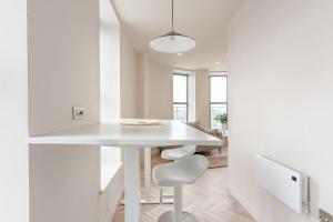 リーズにあるLuxury 2-Bedroom Penthouse with Stunning Views and Parking - Leeds City Centreの白いテーブルと椅子のある白いキッチン