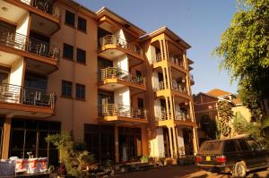 an apartment building with a van parked in front of it at Tristar Hotel Kampala in Kampala