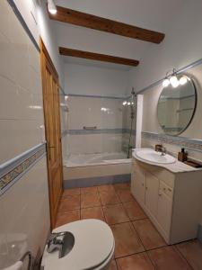 a bathroom with a toilet and a sink and a tub at Casa Rosa in Alcalalí
